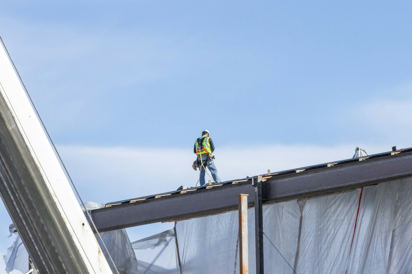 a man with workers' compensation insurance standing on top of a metal structure